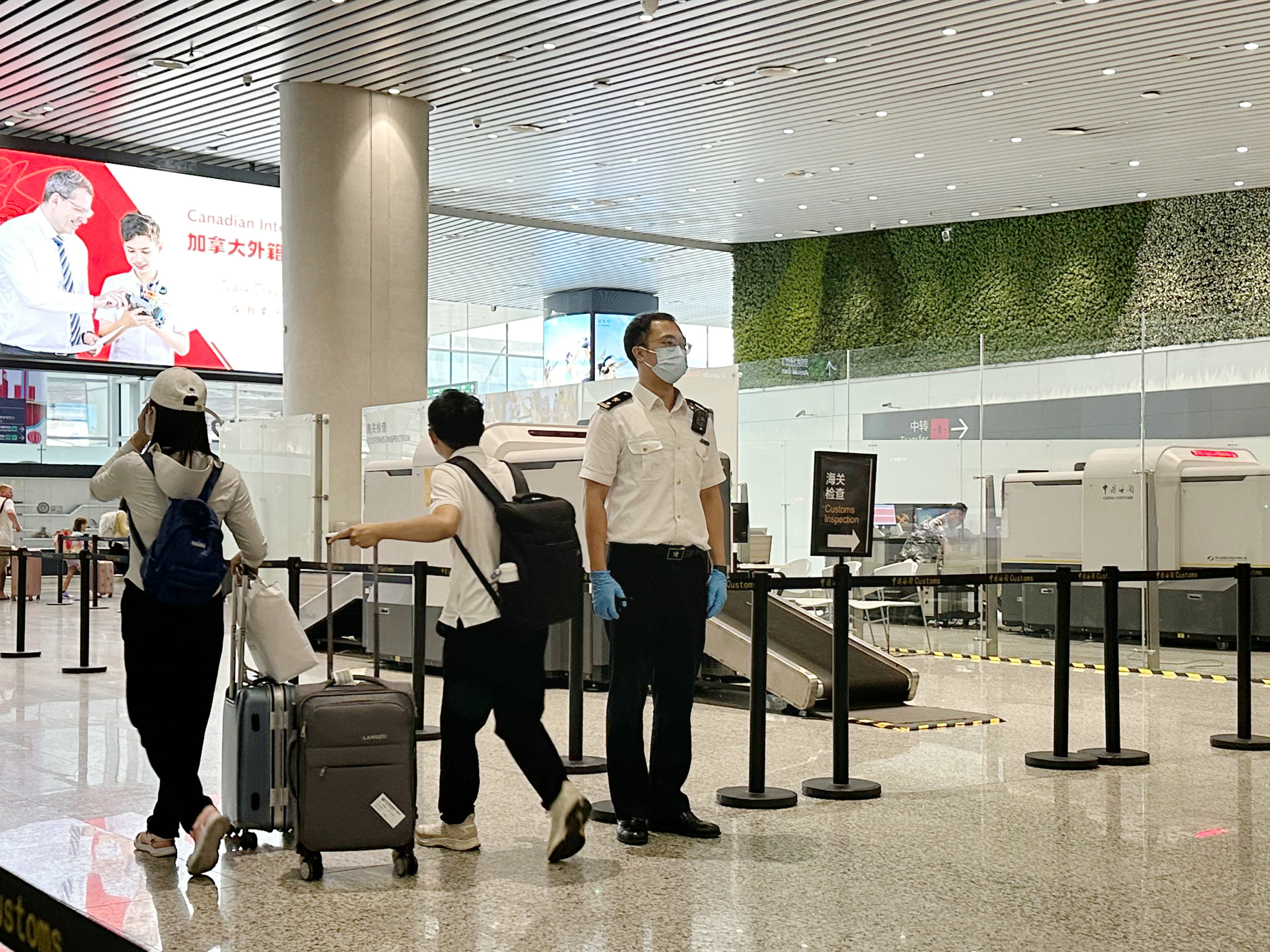 圖為：國慶假期期間，廣州白雲機場海關關員對進境旅客進行監管（關蕓攝）.jpg